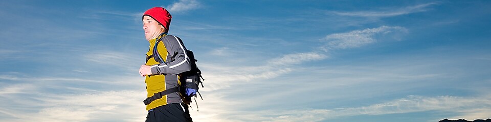 hombre con pierna protésica y ropa deportiva corriendo por la montaña al amanecer