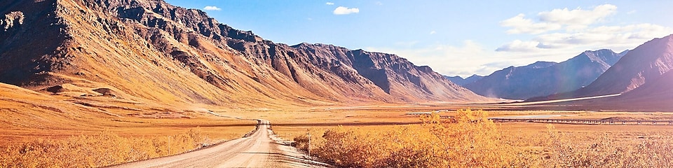 Carretera desierta sin asfaltar rodeada de montañas