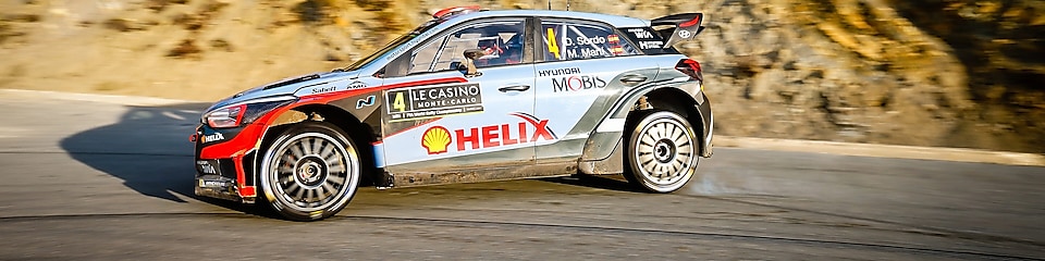 Coche de rally derrapando en una curva en el Campeonato del Mundo de Ralis