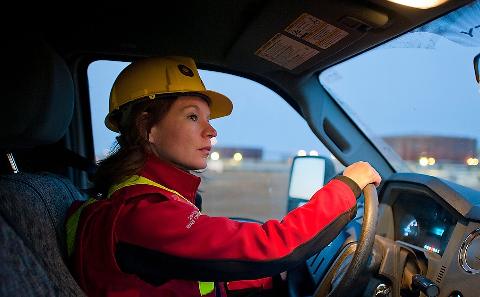 Señora con equipo de seguridad conduciendo un vehículo